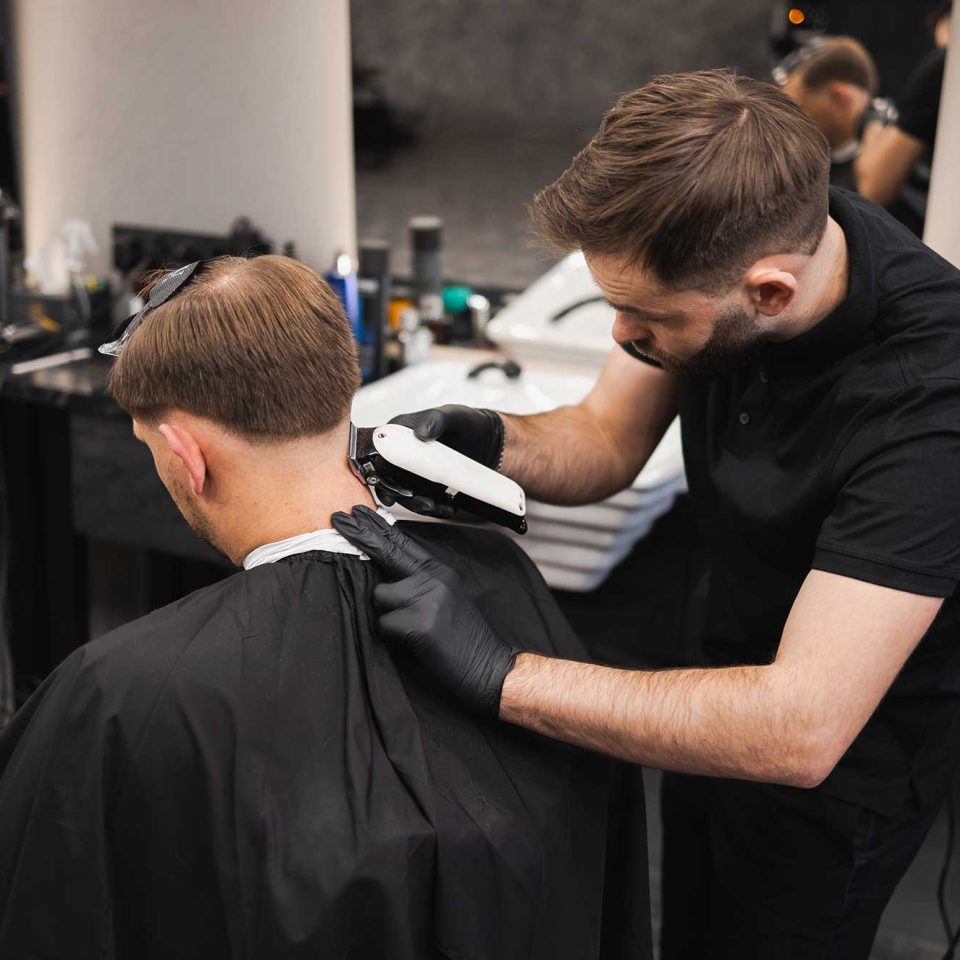 male-hairdresser-making-a-haircut-for-a-young-man-2022-02-17-20-02-40-utc