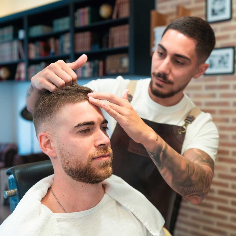 young-hairdresser-with-tattoos-styling-the-male-cu-2023-01-18-19-36-34-utc