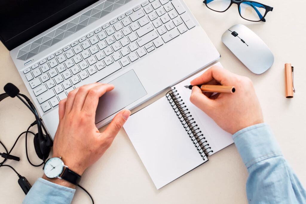 top-view-of-a-freelancer-making-notes-while-workin-2023-03-07-04-37-15-utc