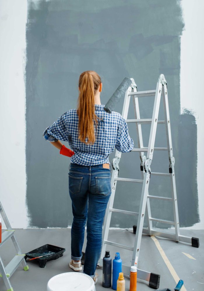 female-house-painter-looking-on-wall-back-view-2021-08-27-09-27-56-utc-scaled.jpg