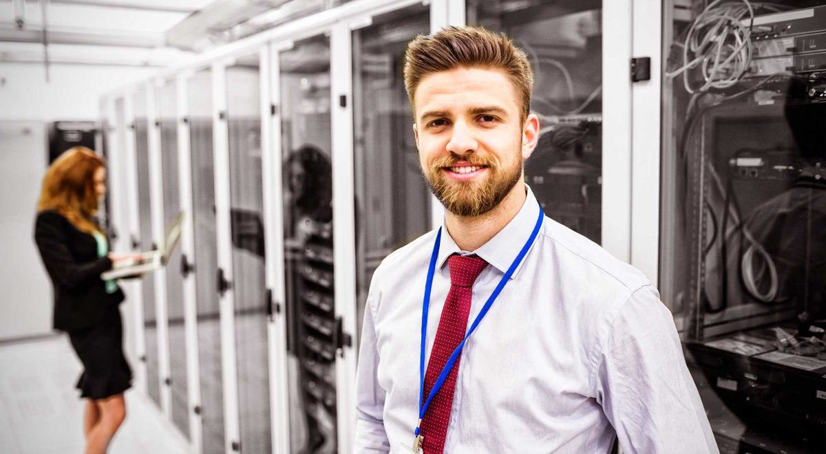 smiling-technician-standing-in-a-server-room-2021-08-30-06-01-14-utc