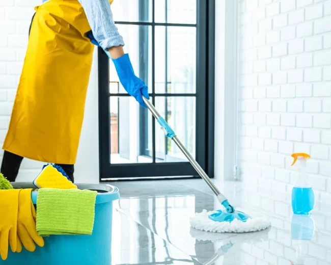 happy-young-woman-blue-rubber-using-mop-while-cleaning-floor-home