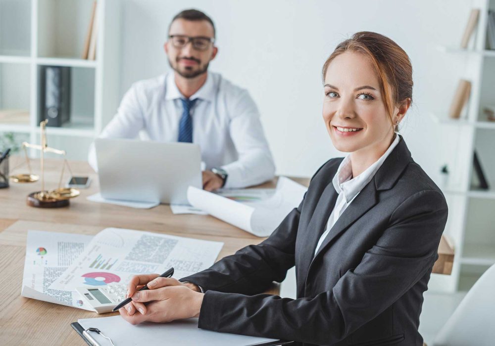 smiling-financiers-looking-at-camera-in-office-2023-11-27-05-34-53-utc